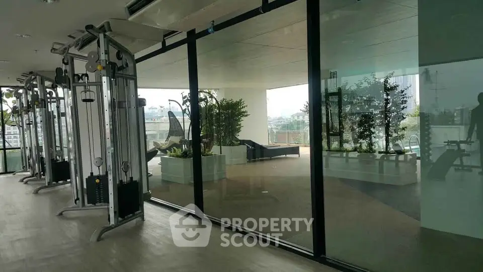 Modern gym with glass walls and outdoor view in luxury apartment building