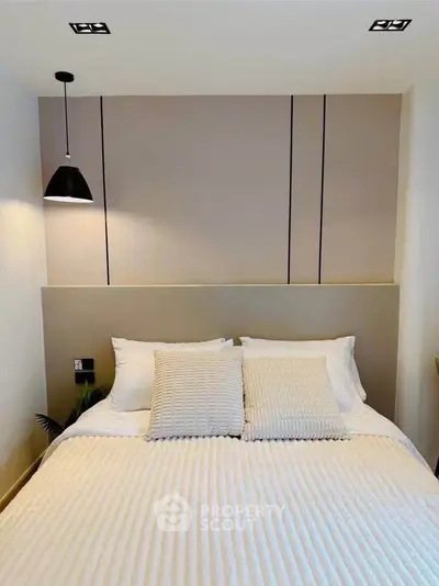 Modern bedroom with stylish decor and cozy bedding in a contemporary apartment.