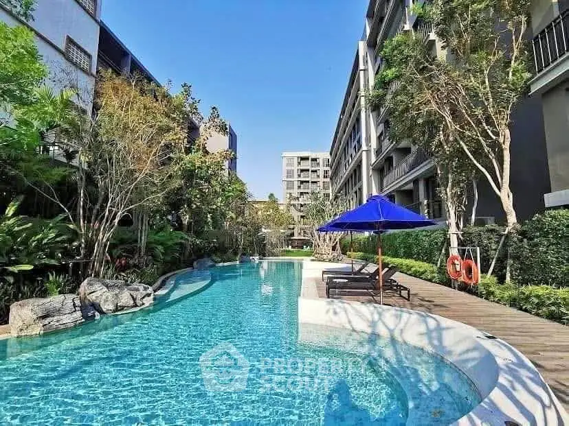 Luxurious apartment complex with stunning outdoor pool and lush greenery.
