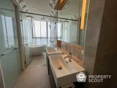 Luxurious bathroom with dual sinks and freestanding bathtub offering stunning city views.