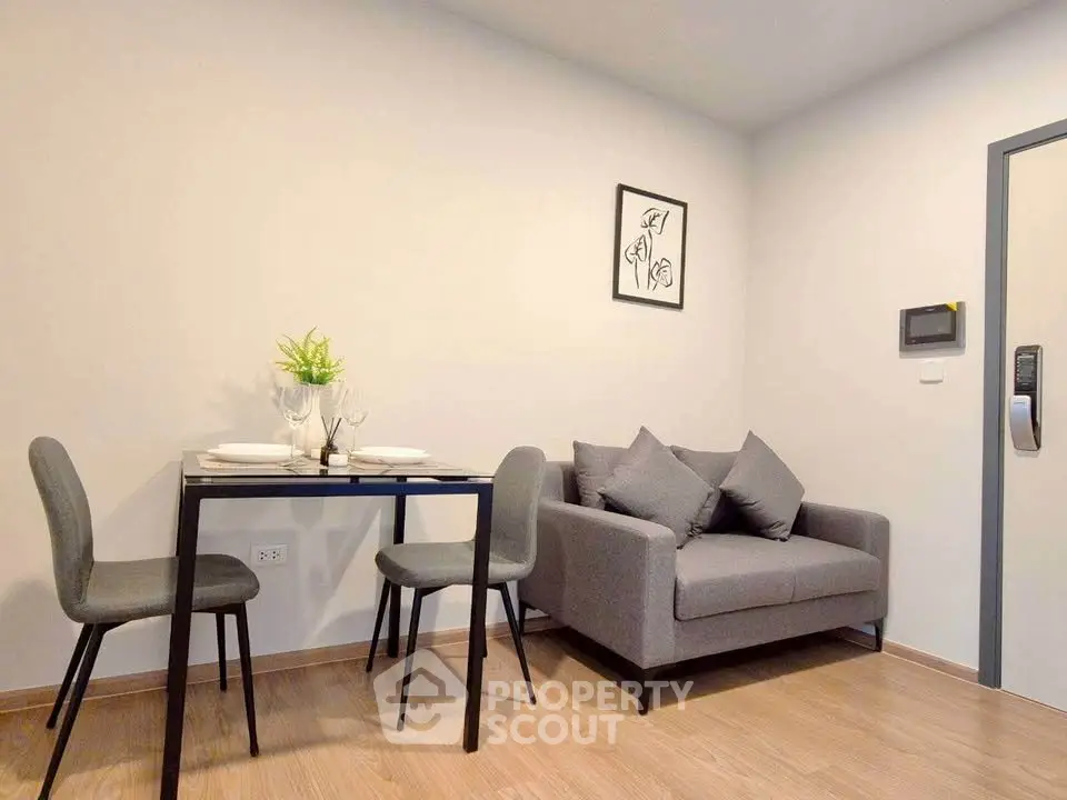 Modern living room with cozy gray sofa and dining area in stylish apartment.