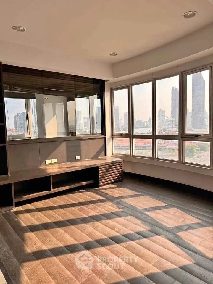 Spacious living room with panoramic city view and abundant natural light.