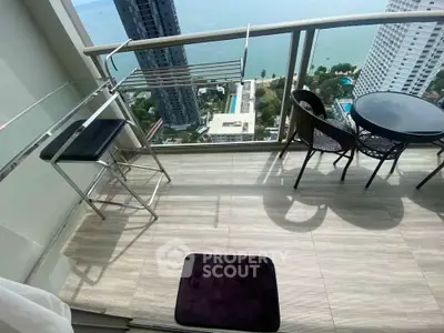 Stunning high-rise balcony with ocean view and modern outdoor seating.