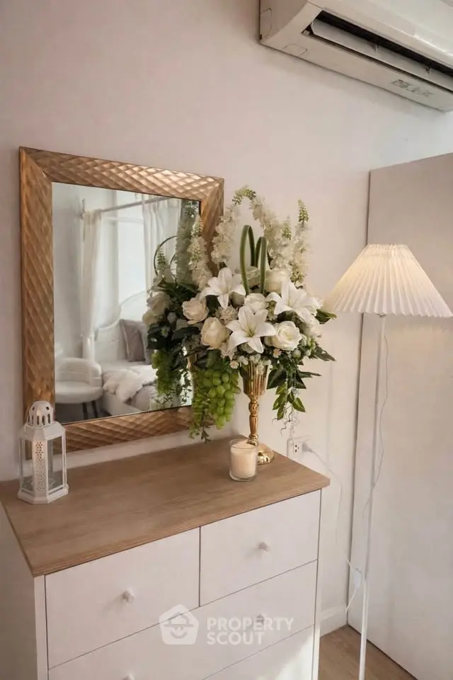 Chic interior with elegant dresser, mirror, and floral arrangement in cozy living space.
