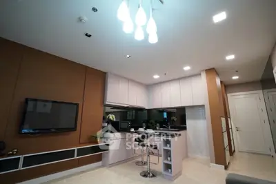 Modern open-layout kitchen with sleek design and stylish lighting in a contemporary apartment.