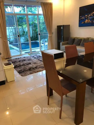 Charming living room with pool view, modern furniture, and elegant decor.