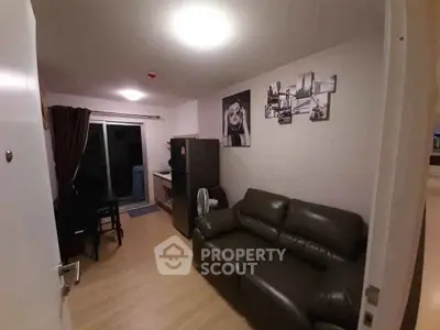 Cozy living room with leather sofa and modern decor in a compact apartment.