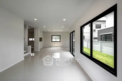 Spacious modern living room with large windows and glossy tile flooring