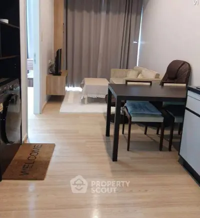 Modern living room with dining area and washing machine, featuring cozy decor and wooden flooring.