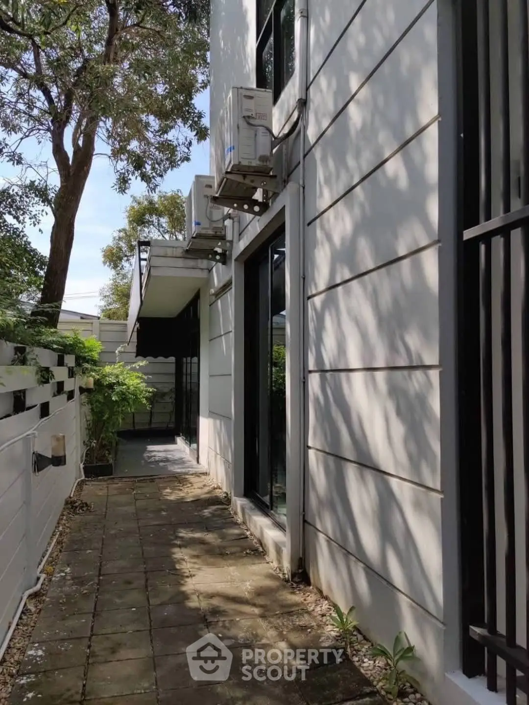 Modern exterior view of a stylish building with sleek design and lush greenery.
