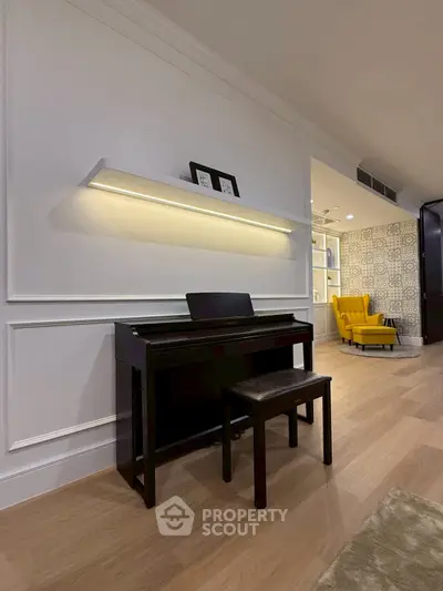 Elegant living room with piano and modern lighting, featuring stylish decor and cozy seating.