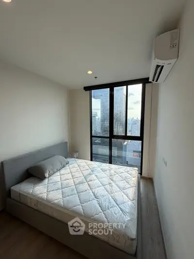 Modern bedroom with city view and air conditioning in high-rise apartment