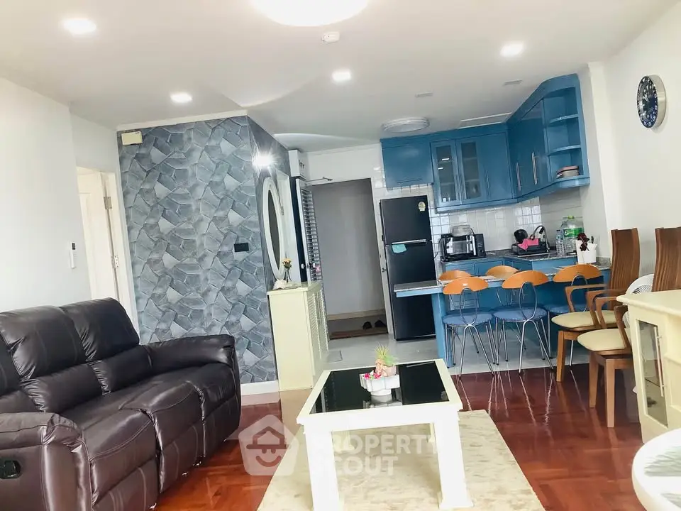 Spacious living room with modern kitchen and stylish decor in open layout apartment.
