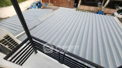 Modern balcony view overlooking metal rooftops and residential area