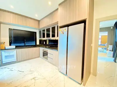 Modern kitchen with sleek appliances and marble flooring in a stylish home.