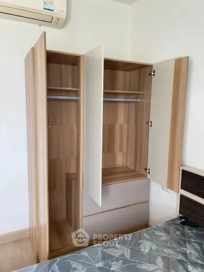 Modern bedroom with open wooden wardrobe and air conditioning unit