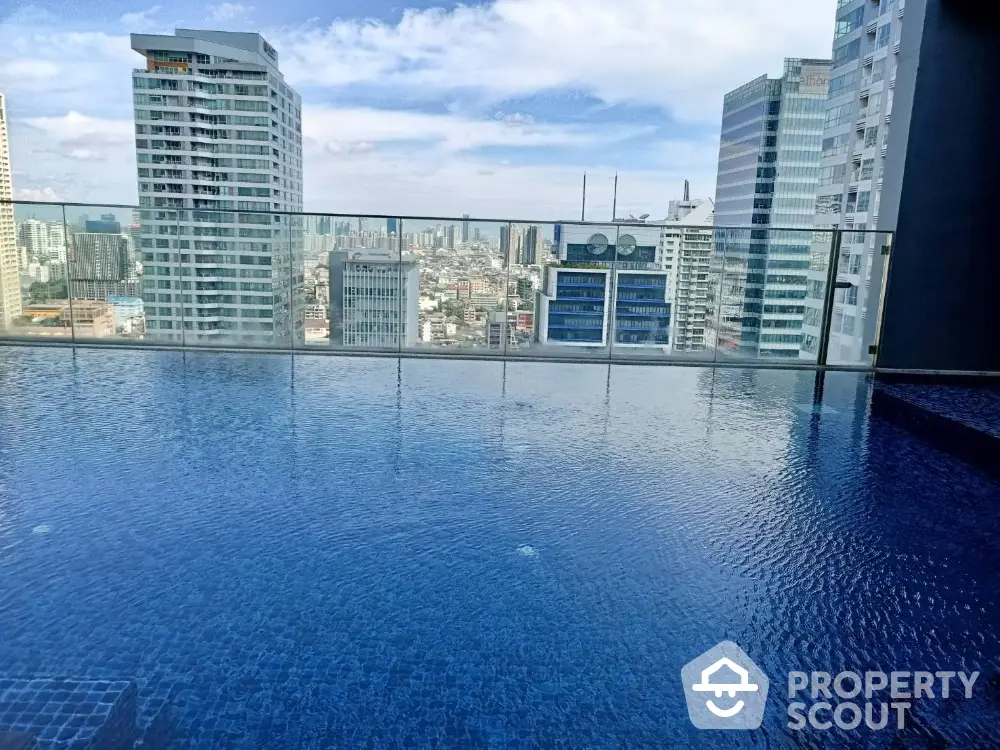 Stunning rooftop pool with panoramic city skyline views in luxury high-rise building.