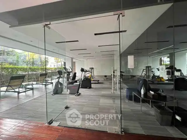 Modern gym with glass walls and fitness equipment in a residential building