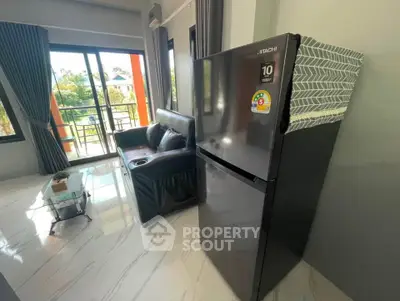 Modern living room with sleek fridge and balcony view, perfect for urban living.
