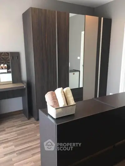 Modern bedroom with sleek dark wood furniture and stylish decor accents.