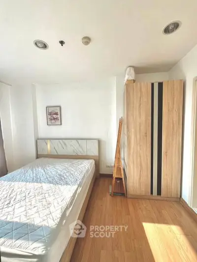 Bright and cozy bedroom with wooden flooring and modern furniture