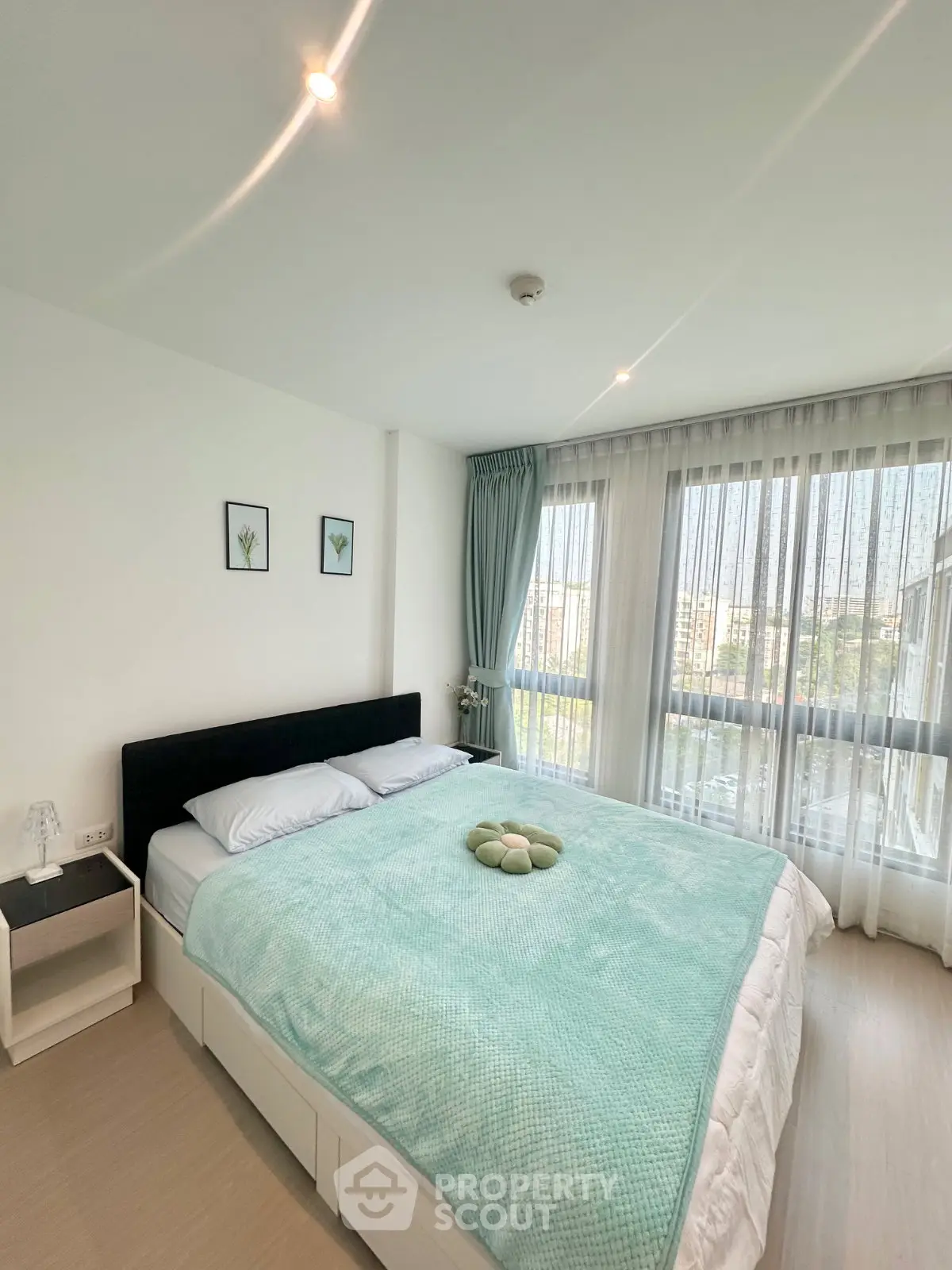 Bright and airy bedroom with large windows and modern decor in a stylish apartment.