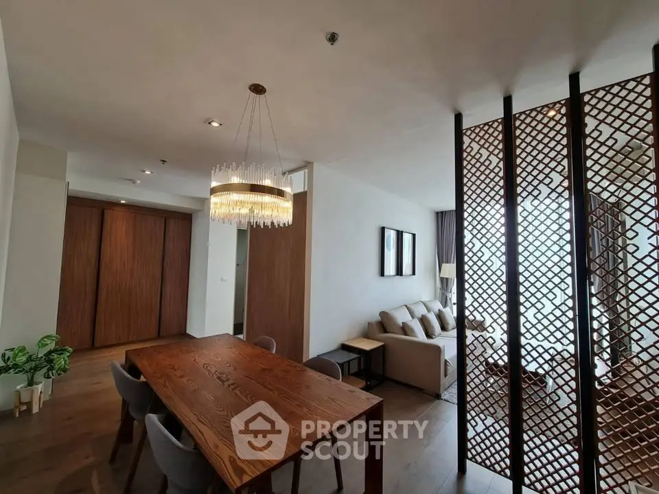 Elegant open-plan living and dining area with modern decor and stylish lighting