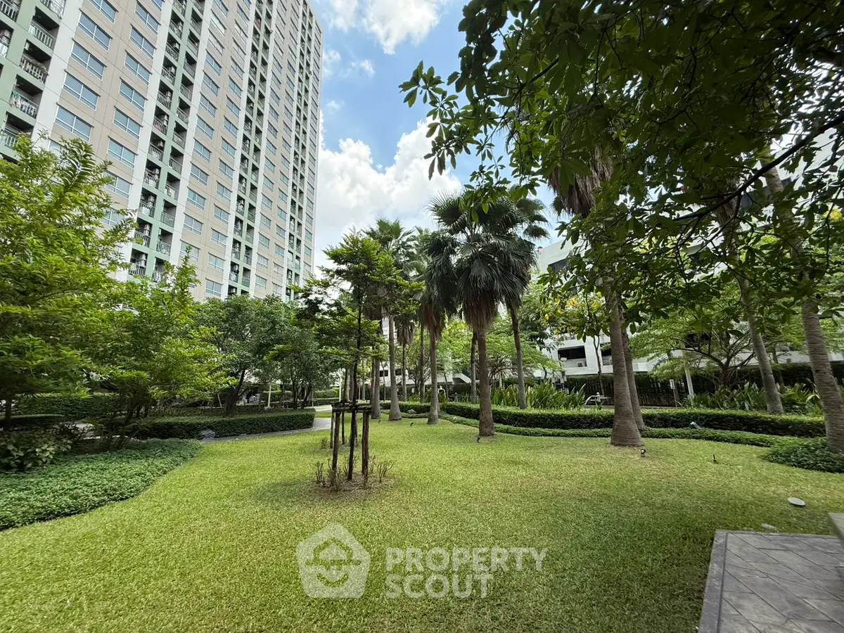 Lush garden view with tall residential building and vibrant greenery, perfect for relaxation and outdoor activities.