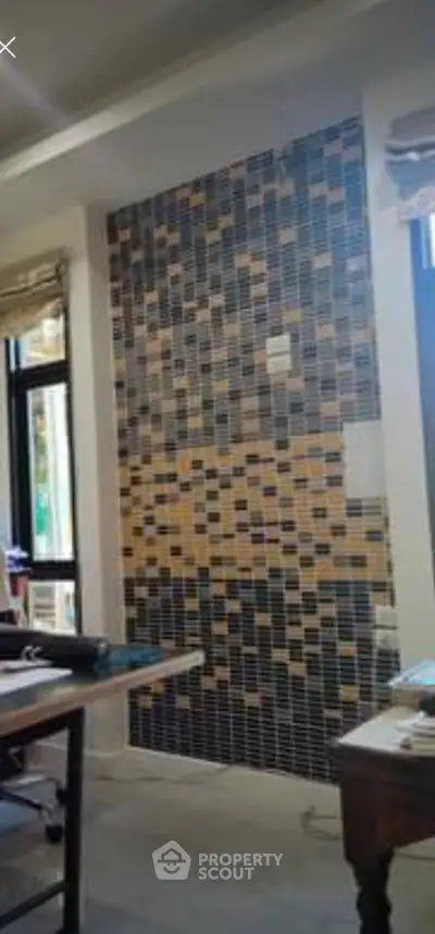 Stylish interior wall with mosaic tile design in a modern living space.