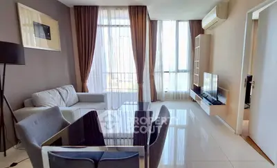 Modern living room with sleek furniture and large windows offering natural light.