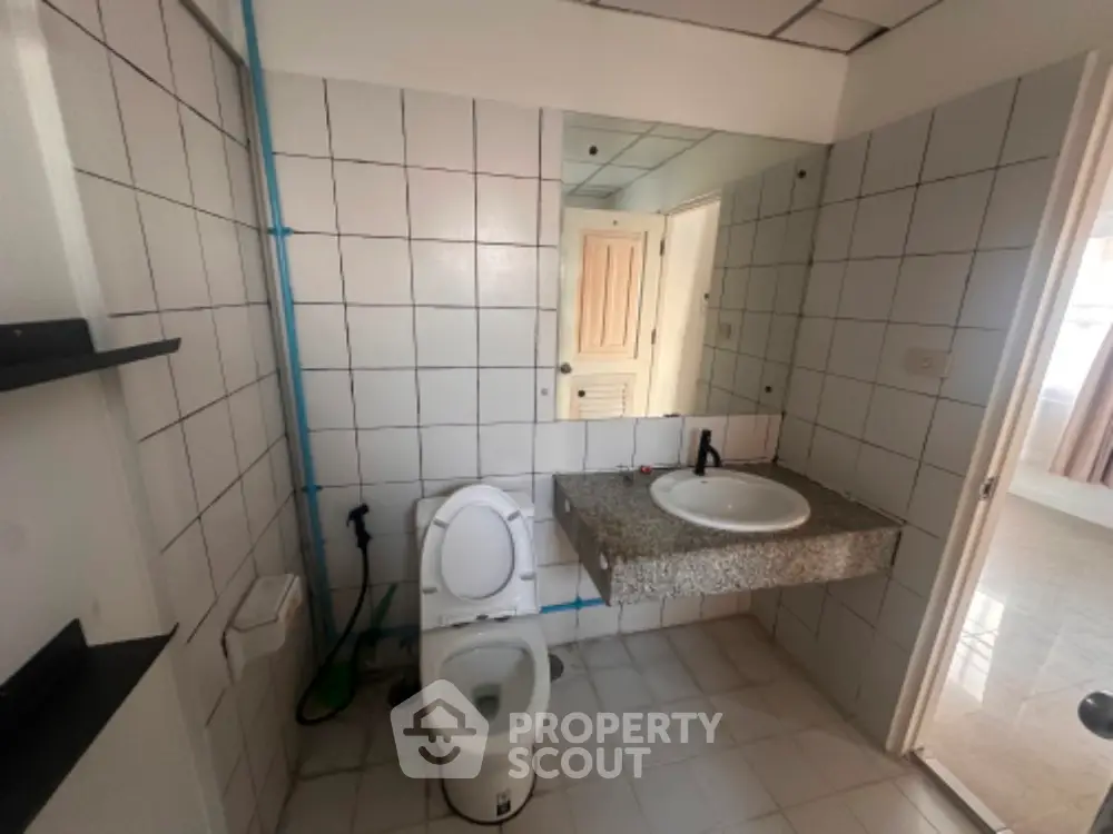 Spacious bathroom with modern fixtures and tiled walls in a contemporary home.
