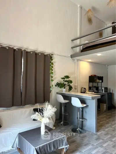 Modern loft apartment with stylish living area and open kitchen layout, featuring a cozy mezzanine bedroom.
