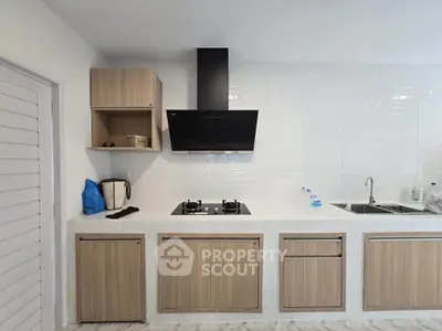 Modern kitchen with sleek cabinets and gas stove, perfect for culinary enthusiasts.