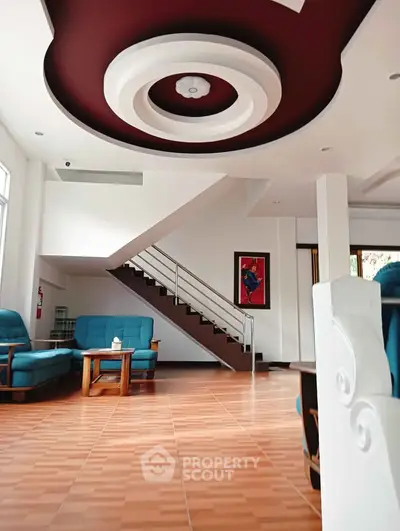 Spacious living room with modern ceiling design and elegant staircase