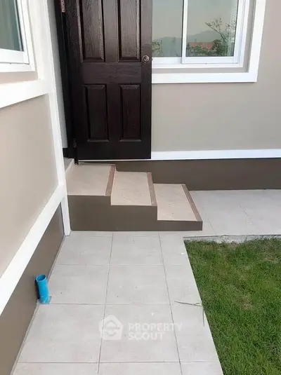 Charming entrance with modern steps and lush green lawn