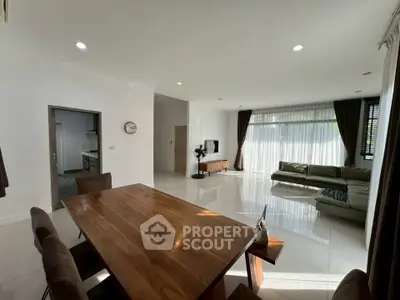 Spacious modern living room with elegant dining area and ample natural light.