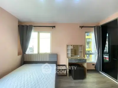 Modern bedroom with large windows and stylish furniture in a well-lit apartment.