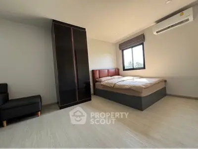 Spacious modern bedroom with stylish decor and ample natural light.