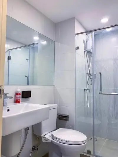 Modern bathroom with glass shower and sleek fixtures in a contemporary apartment.