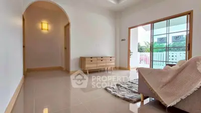 Spacious living room with modern decor and large windows opening to a balcony with a scenic view.