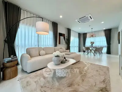 Luxurious modern living room with elegant decor and dining area, featuring plush seating and ambient lighting.