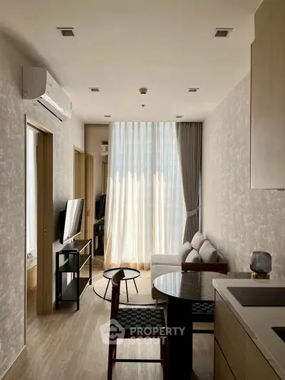 Modern living room with natural light, cozy sofa, and stylish decor in an open layout apartment.