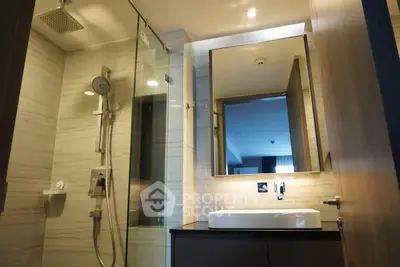 Modern bathroom with sleek shower and stylish vanity in luxury apartment.