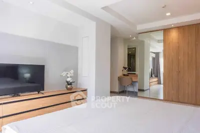 Modern bedroom with sleek wooden furniture and large mirror closet