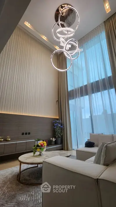 Luxurious modern living room with high ceilings and elegant chandelier