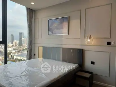Modern bedroom with city view and stylish decor in high-rise apartment.