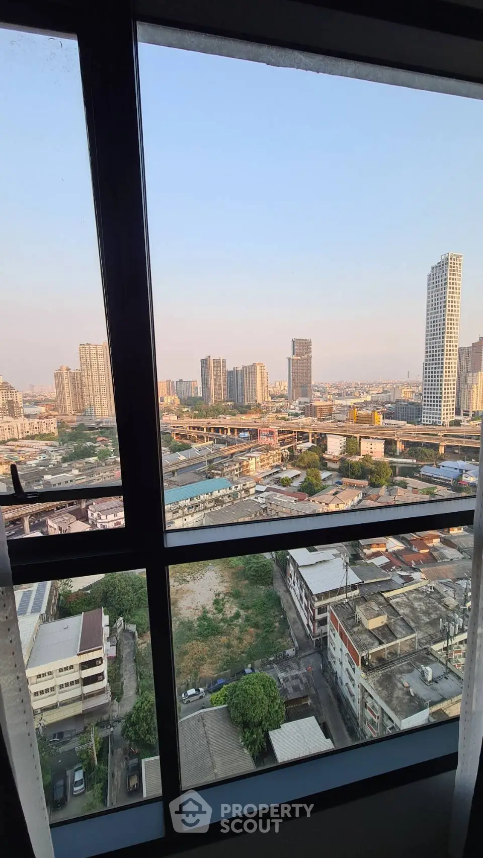 Stunning cityscape view from high-rise apartment window, showcasing urban skyline and vibrant city life.