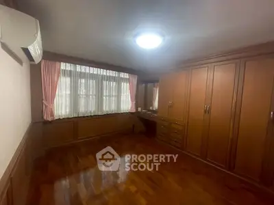 Spacious bedroom with wooden flooring and built-in wardrobe