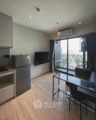 Modern living room with balcony view, sleek furniture, and natural light in urban apartment.