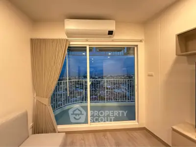 Modern living room with balcony and city view, featuring air conditioning and elegant curtains.